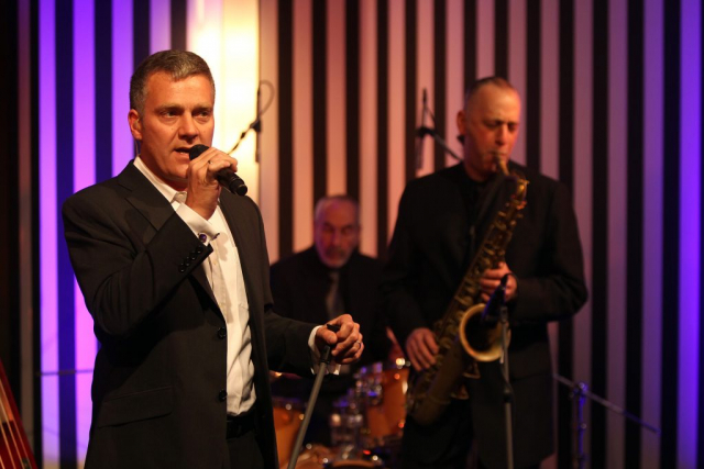 Tom Rust singing with mic and backing band