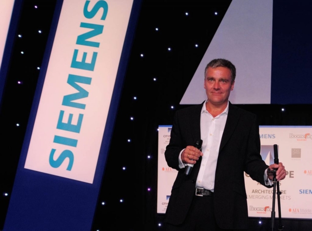 Tom Rust with Siemens banner at corporate event